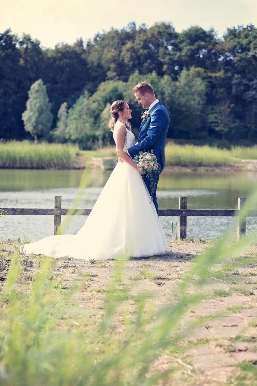 Marjon in trouwjurk bij het water